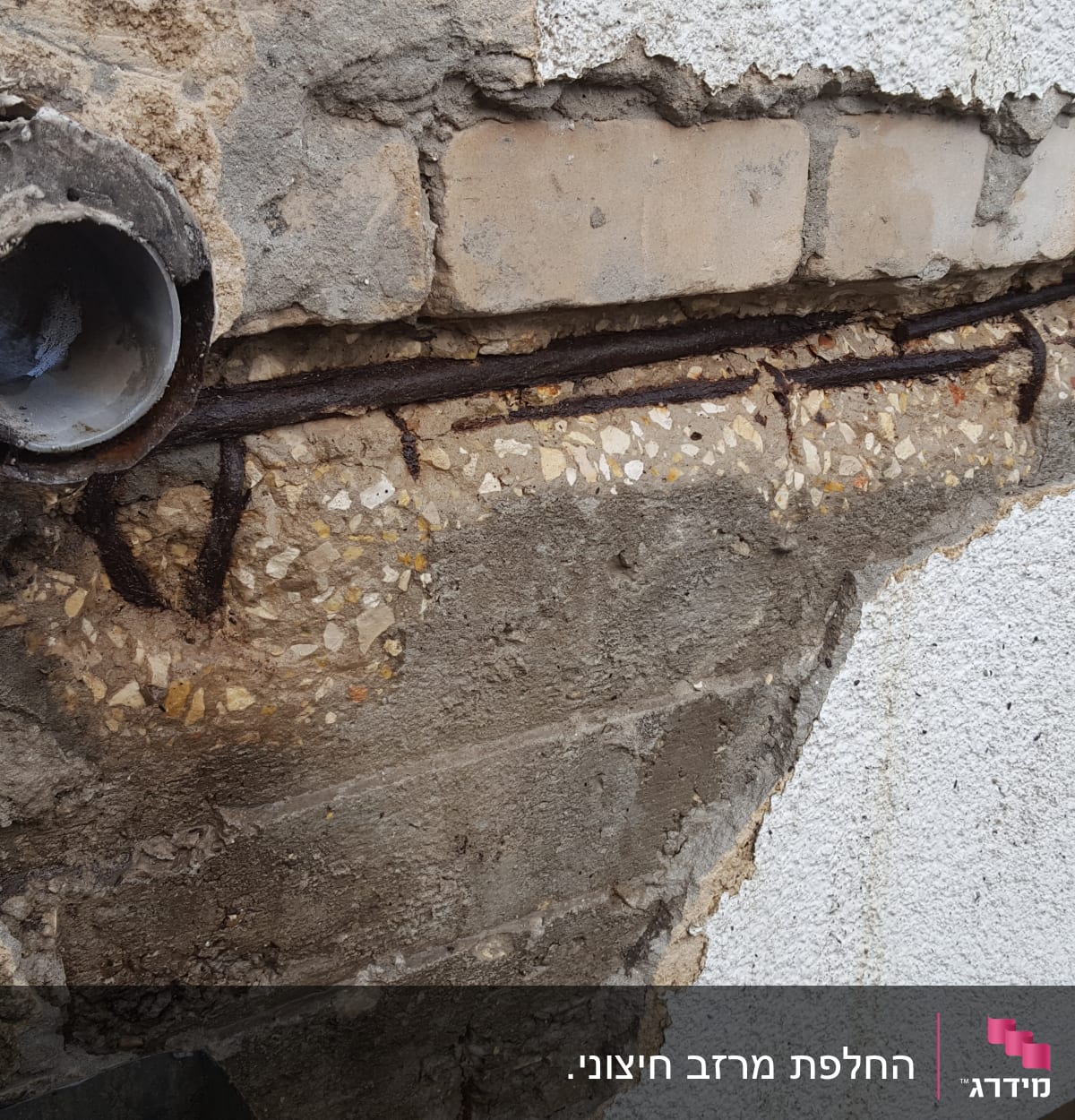 צינור מתכת חלוד על גג עם בטון חשוף